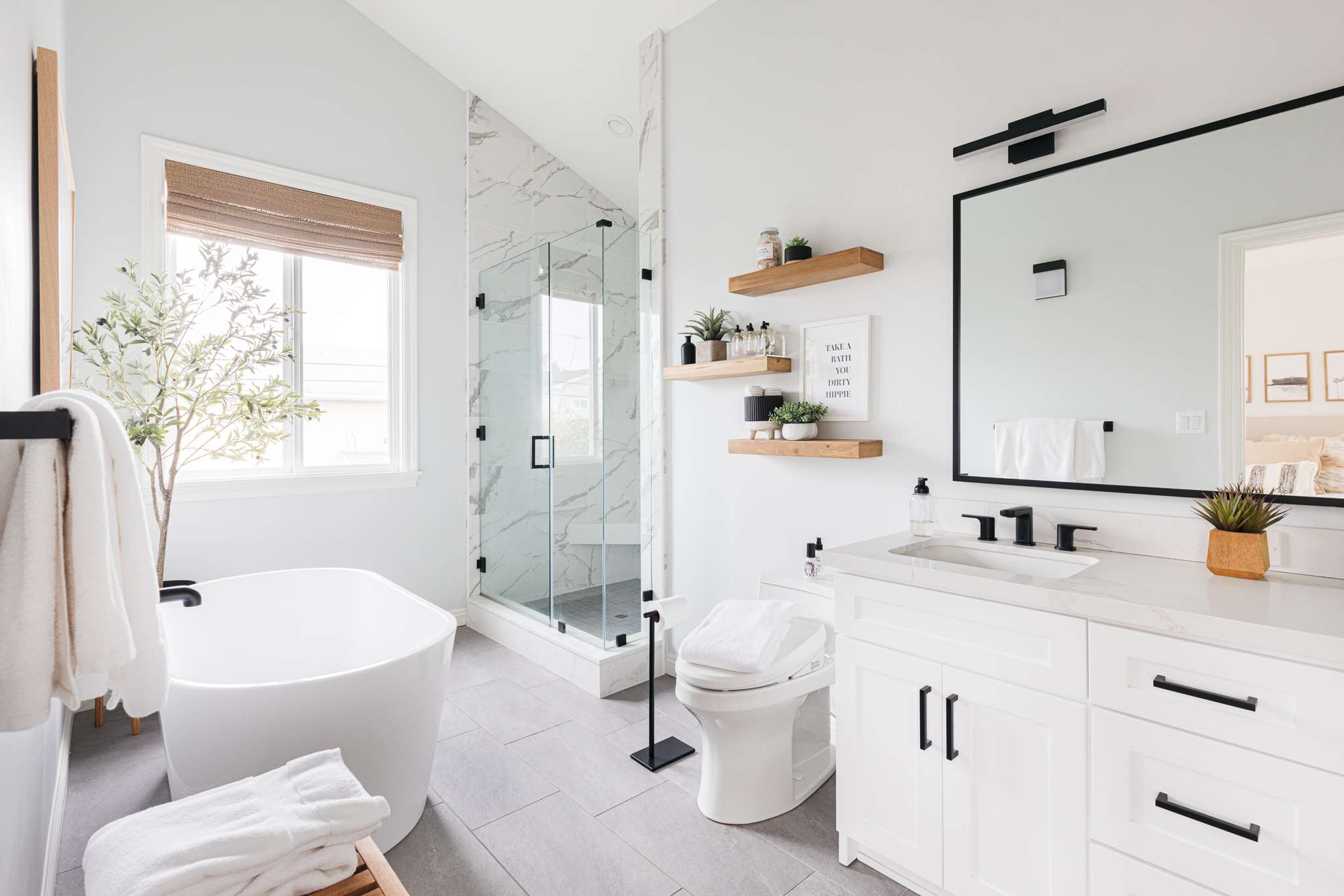 Modern white bathroom with freestanding tub and glass shower