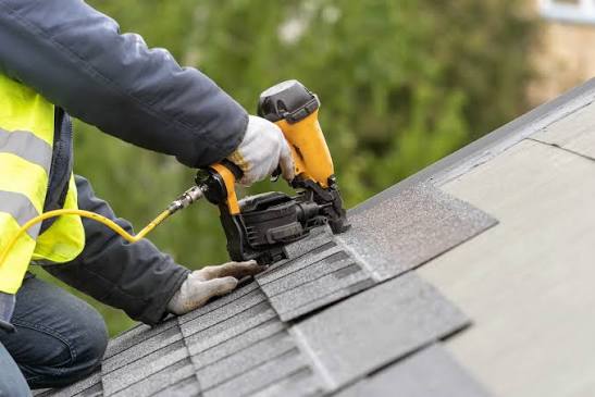 Roofing professional installing shingles on a home roof